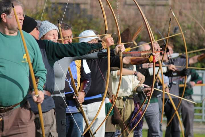 Row of longbow archers drawing their bows